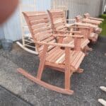 Handcrafted cedar rocking chair displayed outdoors at Athens Woodcrafters.