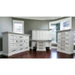 Elegant white wooden furniture set in a bright room with large windows.