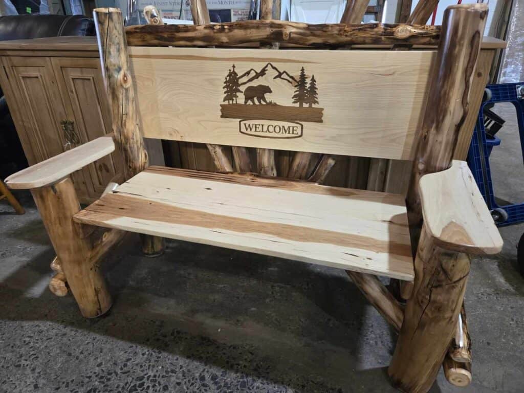 Rustic log bench with bear and nature scene, welcoming outdoor furniture piece.