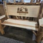 Rustic log bench with bear and nature scene, welcoming outdoor furniture piece.