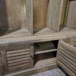 Wooden mud room cabinet with coat hooks and storage compartments.