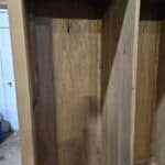 Unfinished wooden mud room cabinet with coat rack hook for entryway storage.