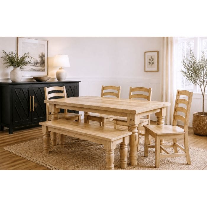 Natural pine farmhouse dining table with matching chairs and bench in a bright dining room.
