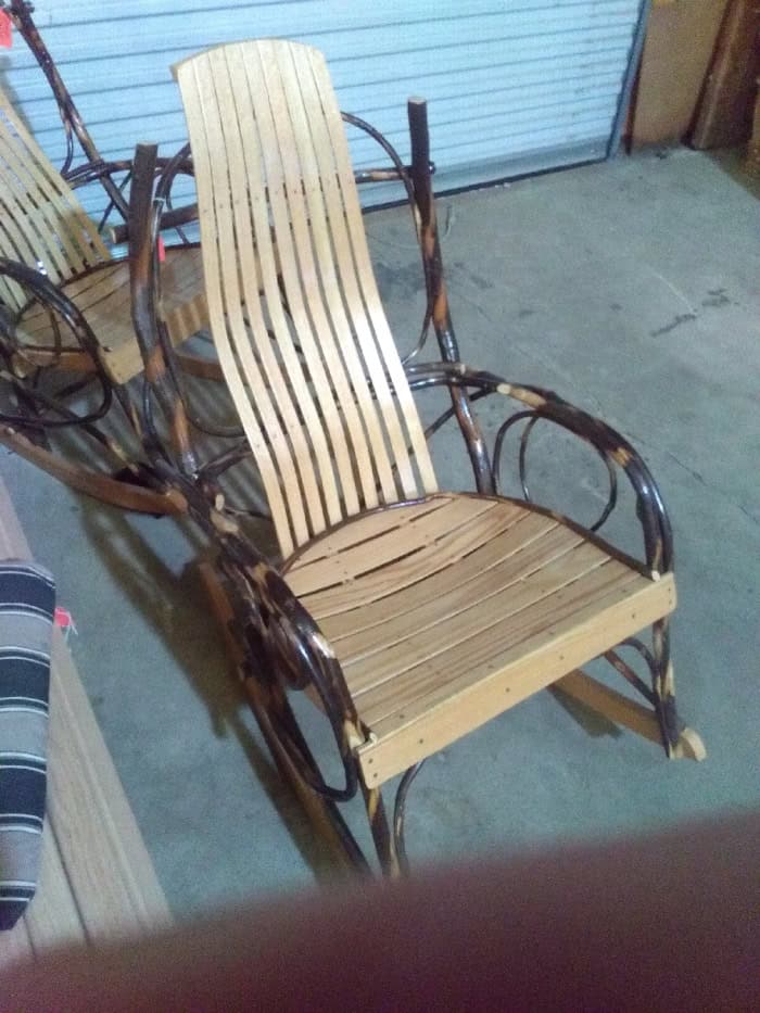 Wooden chair with rattan frame and slatted backrest for outdoor use.